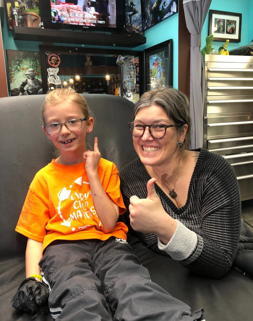 George with a piercing client, both giving a thumbs up