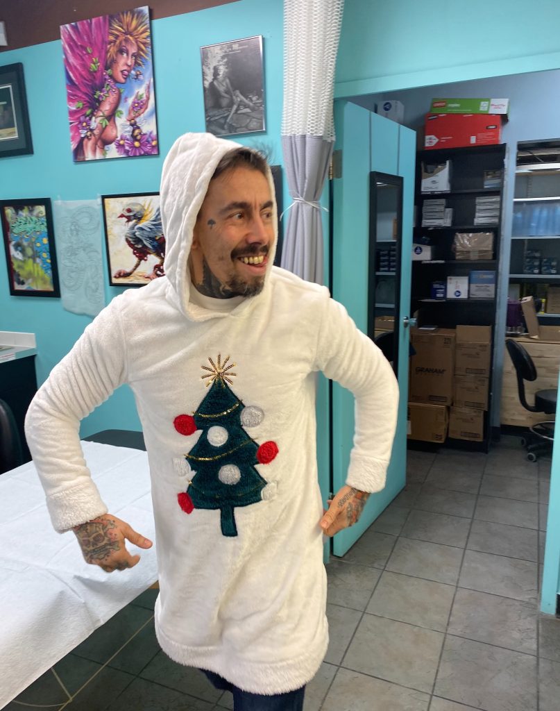 A Strange World artist wearing a Christmas tree sweater in the shop