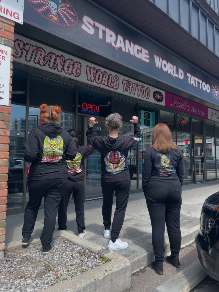 Staff outside the Strange World Tattoo storefront on Crowchild Trail