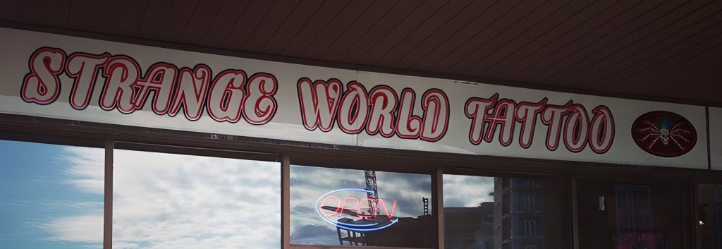 The Strange World Tattoo storefront sign on Crowchild Trail N.W.