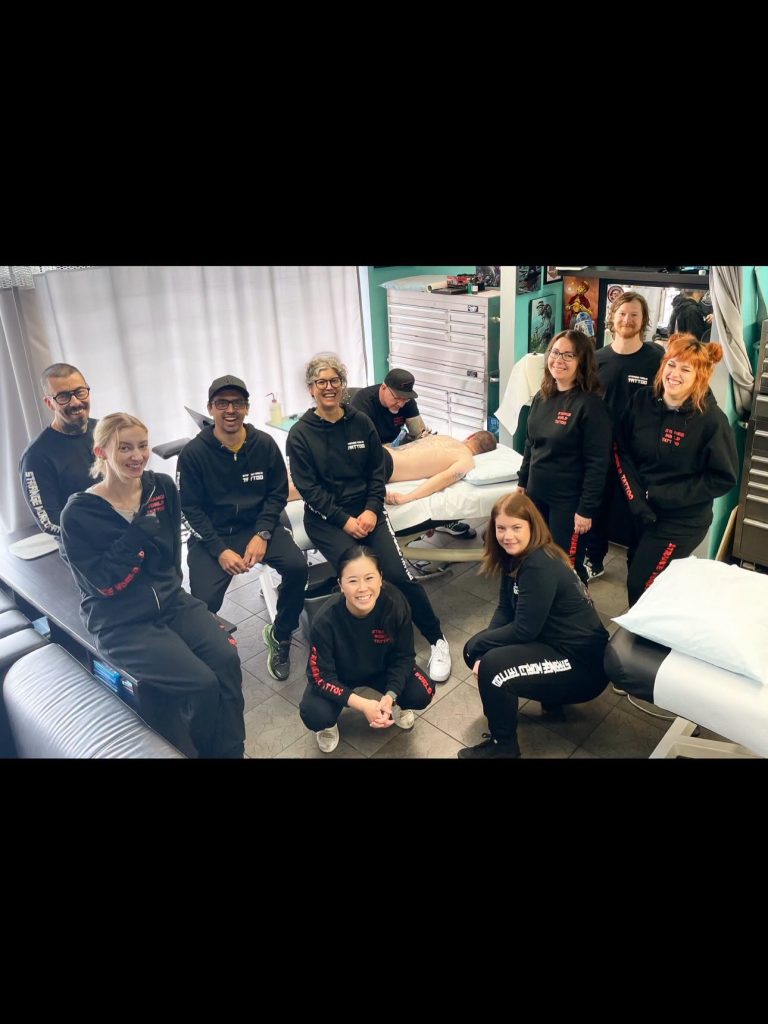 The Strange World crew gathered together in the shop