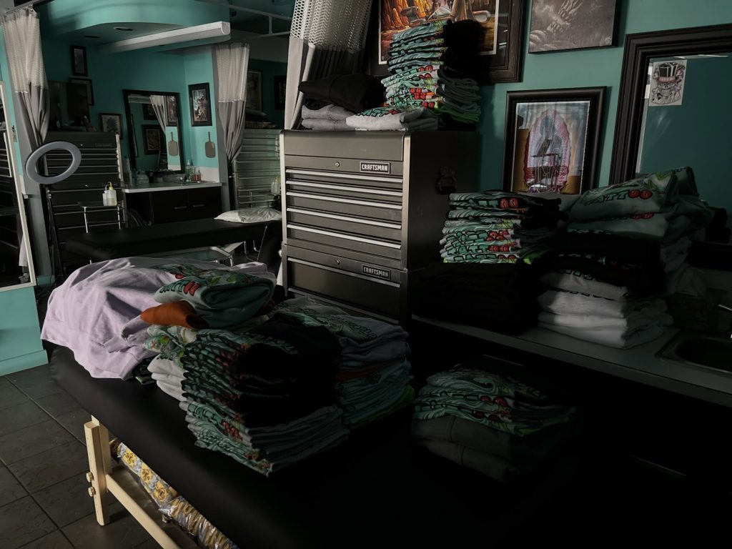 Merch and prints on the wall at Strange World Tattoo