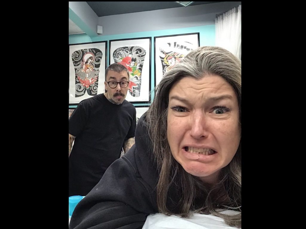 Two Strange World staff pulling faces at the camera in the studio