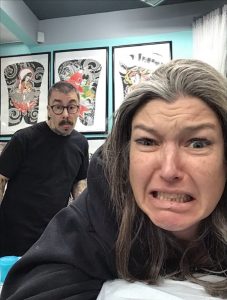 Two Strange World staff pulling faces at the camera in the studio
