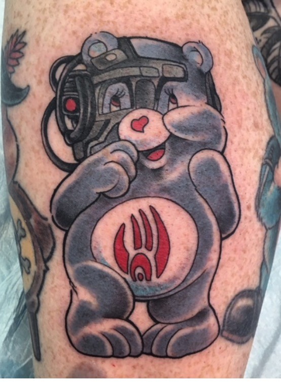 Full-colour Care Bear wearing a tactical headset, tattooed on a leg by Brett Schwindt
