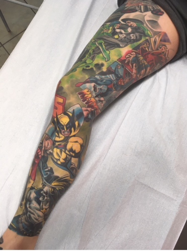 Full-colour comic book leg sleeve featuring Wolverine and Superman, tattooed by Brett Schwindt